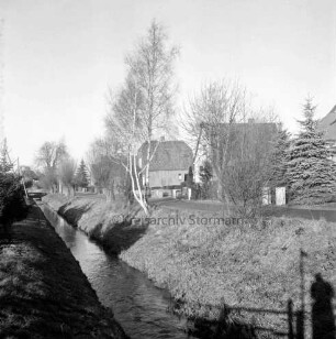 Barnitz: Bassgraben: hinten Mitte Baumreihe: rechts dahinter Ölmühle mit Wohnhäusern und Vorgärten: hinten links Brücke