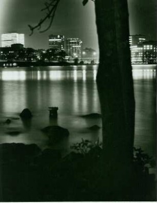 Hamburg bei Nacht. Blick über die Alster auf beleuchtete Geschäftshäuser