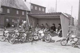 Mopedfahrer an der Bushaltestelle