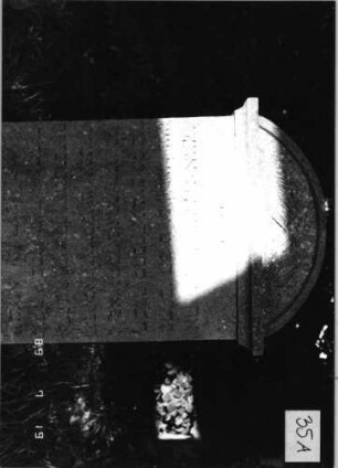 Grabstein 35 (Index: 99796337) Material: Sandstein Zustand: verwittert mit Textverlust Maße HxBxT: 97x56x11 cm Beschreibung: Stele, Abdeckplatte mit Segmentbogenaufsatz Symbolik: gekreuzte Palmzweige: Grabstein 35A