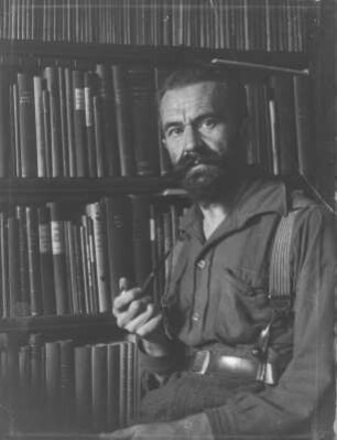 Rudolf Zimmermann : Portrait von Rudolf Zimmermann vor einem Bücherregal.