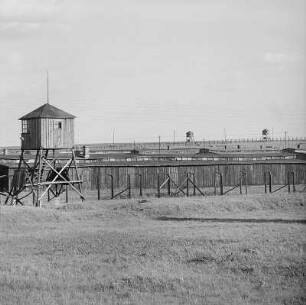 Lublin-Majdanek. Gedenkstätte ehem. Konzentrationslager Majdanek. Wachturm und Elektrodoppelzaun gegen Baracken