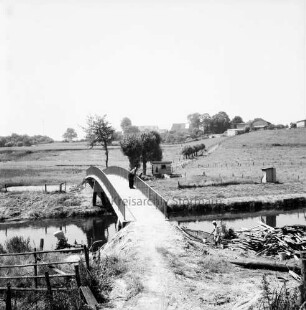 Klein Barnitz: Trave: Brückenbau: Blick auf neue Fußgängerbrücke: im Hintergrund Klein Barnitz: vorn rechts Überreste der alten Holzbrücke mit Arbeitern