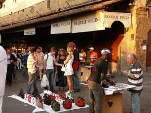 Schwarzafrikaner verkaufen nach Ladenschluß der Geschäfte auf der Ponte Vecchio gefälschte Markenartikel an Passanten