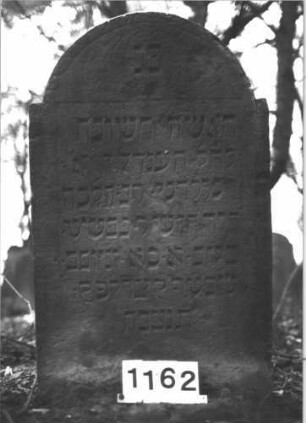 Grabstein 1162 (Index: 99899883) Material: Sandstein Zustand: einige Abbrüche im Stein, sonst gut erhalten Maße HxBxT: 107x63x9 cm Beschreibung: Stele mit eingezogenem Rundbogenabschluss: Grabstein 1162