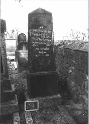 Grabstein 107 (Index: 100114124) Material: Granit Zustand: gut Maße HxBxT: 184x48x20 cm Beschreibung: Obelisk, getreppter Sockel Besonderheit: kulturhistorisch wertvoll / hist.-wiss. Gründe: Grabstein 107