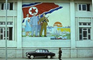 Nord-Korea 1981, GroßPlakat in Pjöngjang, davor Wolga Auto