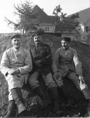 1. Weltkrieg. Drei Soldaten, an einem Hang sitzend