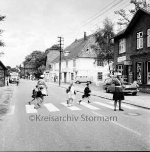 Hamburger Straße / B 75: Fußgängerüberweg: Schülerlotsen geleiten Schulkinder über Zebrastreifen: Bildmitte Gaststätte Lindenhof