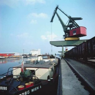 Regensburger Hafen. Blick auf ein Frachtschiff beim Be- oder Entladen durch einen Hafenkran
