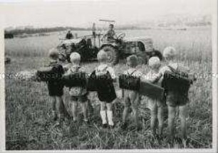 Schulkinder beobachten die Getreideernte