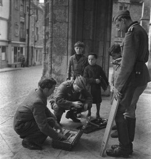 Hellmut Hell (in der Mitte hockend) und Franz Prinz zu Sayn-Wittgenstein (rechts) mit einem Zivilisten (?) und drei Kindern in der Südvorhalle der Kathedrale Saint-Julien in Le Mans (Aufnahme im Rahmen der Fotokampagne im besetzten Frankreich)