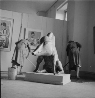 Letzte Arbeiten der Putzfrauen. : Besucher der IV. Deutschen Kunstausstellung Dresden im Albertinum. Raumaufnahme mit "Wildeber" (Aluminium) von Waldemar Grzimek