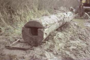 Moorweg: bei Durchlass Alte Alster: Fundstück Rohrleitung aus Holz, nach Bergung: Gesamtansicht, vorne Querschnitt: hinten Bagger