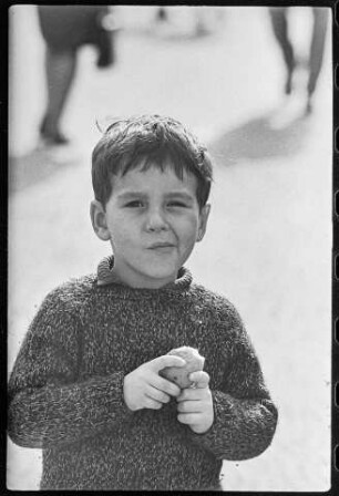 Kleiner Junge mit einer angebissenen Pellkartoffel in der Hand, 1966. SW-Foto © Kurt Schwarz.