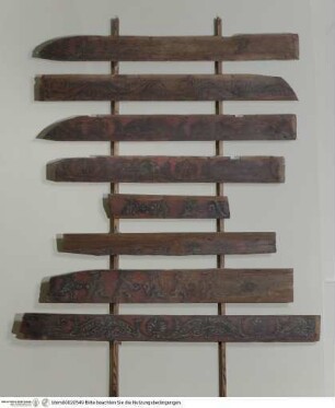Acht Fragmente der ehemaligen Holzdecke mit kämpfenden Kriegern und Palmetten- und Rankenornament