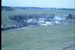 Ortsrand mit großen Gebäuden in einem Wiesengrund im Fraubachtal