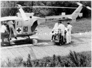 Ärzte versorgen einen Kranken, daneben Helikopter (Altersgruppe 14-17)