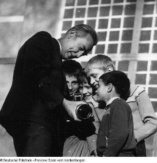 Fotograf Erich Pohl (1904-1968) mit Kindern, denen er seine Kamera vorführt. Dresden?