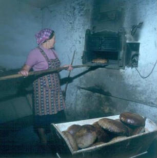 Landwirtin bem Backen von Brot in einem Backofen