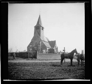 Tourmignies (Dep. Nord, Frankreich): "Kirche [Saint-Pierre-d'Antioche] von Tourmignies" mit Friedhof, im Vordergrund ein Soldat mit 2 Pferden auf einem Feld (Distanzaufnahme)