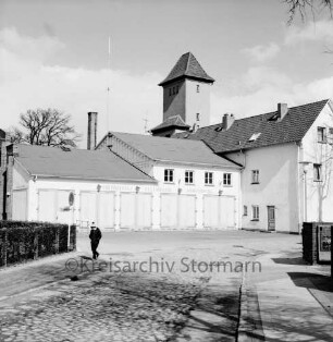 Feuerwache Woldenhorn: Schäferweg: [ehemaliges Elektrizitätswerk]: Feuerwehrgerätehaus mit Funkantenne: rechts Verwaltungsgebäude: dahinter Schlauchturm: vorne Junge auf Gehweg, links Hinweisschild "Stadtverwaltung"