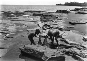 Kinder am Strand : Kinder am Strand des Mbini, die mit einem Tuch kleine Fische fangen.