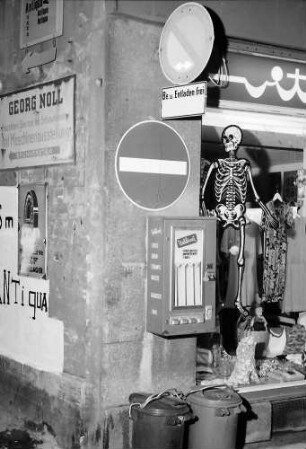 Freiburg: Schild Einbahnstraße, Mülleimer und Schaufenster mit Skelett in der Eisenbahnstraße