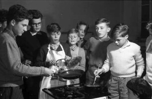 Freiburg: Adelhauser Schule; Jungen lernen Kochen; Jungen am Kochherd beim Pfannkuchenbacken