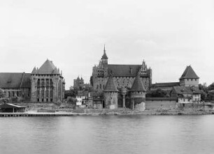 Malbork (Marienburg), Ordensburg Marienburg, Hochmeisterpalast, Hochschloss (Konventshaus) und Herrendansk. Ansicht mit Brücktor von Nordwesten über die Nogat