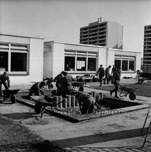 Kinderspielplatz: Evangelischer Kindergarten "Ehmkenberg" im Gemeindezentrum "Haus der Begegnung": Poggenseer Weg: Außengelände: Sandaustausch durch Bundeswehrsoldaten: vorn Sandkiste mit neuen Hölzern: darin und hinten mehrere Soldaten mit Schubkarren: hinten rechts Hochhäuser am Poggenseer Weg