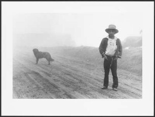Junge mit einem Hund auf einer Straße im Nebel