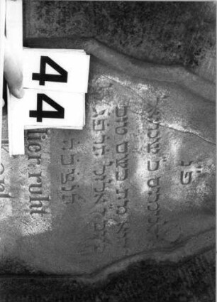 Grabstein 44 (Index: 100100566) Material: Sandstein Zustand: verwittert Maße HxBxT: 139x58x19 cm Beschreibung: Stele, getreppter Sockel, geschwungener Runbdogenabschluß Symbolik: vierblättrige Blüte: Grabstein 44 (Detailaufnahme)