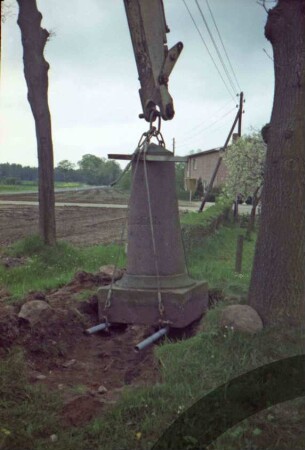 Bargfeld-Rögen: bei Elmenhorster Straße: Umsetzen von Meilenstein [Nr. 7]: Herausheben von alten Standort: Stein an Arm von Bagger
