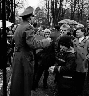 Schlosspark: Ostereiersuchen: Polizist verteilt Süßigkeiten an Kinder: Besucher mit Regenschirmen