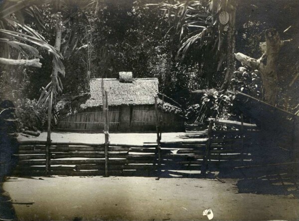 "Men's house in the enclosure. Lasu"