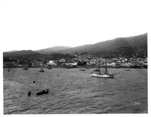 Funchal, Madeira. Blick von der Seeseite auf Stadt und Hafen mit Booten und Zweimaster