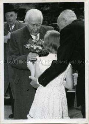 Ein Berliner Kind schenkt Bundespräsident Heuss Blumen