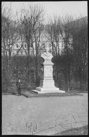 Karlsbad. Goethe-Denkmal mit Grand Hotel Pupp : Karlsbad. Denkmal für Johann Wolfgang von Goethe (1883; Adolf Donndorf). Büste und Postament Marmor. Parkanlage vor dem Grand Hotel Pupp