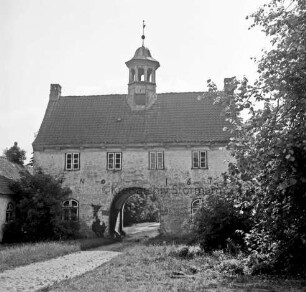 Gut Jersbek: Torhaus: Blick von Westen: links Flügelbau: davor und rechts Gesträuch und Bäume: vorn links Zufahrt