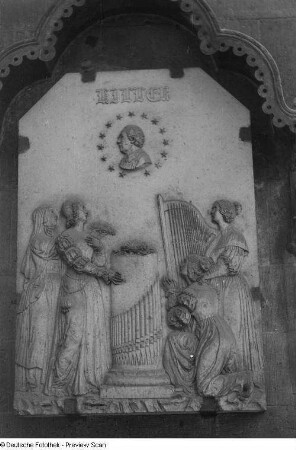 Bildplatte des Denkmals für Thomaskantor Johann Adam Hiller (1728-1804). Entwurf von V. H. Friedrich Schnorr von Carolsfeld, 1830. Ausführung F. Funk und C. J. Wingrich 1831-1832 (Enthüllung 29. Juni 1832, 1888/1903 Entfernung des Denkmals und Anbringung der Bildplatte an der Thomaskirche). Sandstein. Leipzig, Nordwestecke der Thomaskirche
