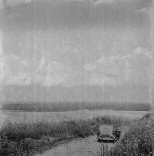 Landstraße : Dr. Kaysers Automobile auf einer Straße durch eine Graslandschaft