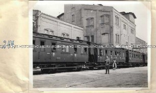Angehöriger der Ordnungspolizei vor einem besetzten Zug auf einem Bahnsteig