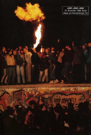 In der Nachr vom 10. November 1989 tanzen Menschen auf der Mauer am Brandenburger Tor in Berlin