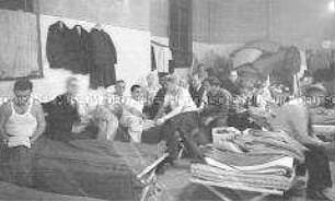 Selbstversenkung des Hochseepassagierdampfers "Columbus" am 19. Dezember 1939, Besatzungsangehörige im Internierungslager auf Ellis Island, auf einfachen Feldbetten sitzend