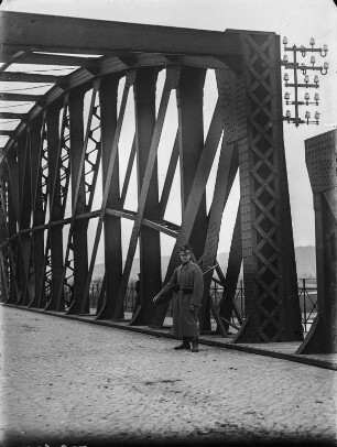 Soldat vor Brücke : Ein Soldat mit einem Gewehr auf einer Stahlfachwerkbrücke.