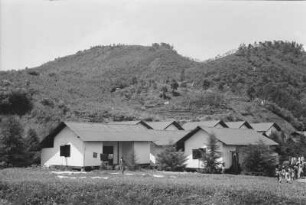 Kleine Teefabrik : Gebäude vor einer bergigen Landschaft