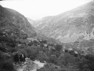 Bergdorf : Blick in ein Gebirgstal mit Dorf. Im Vordergrund zwei Männer