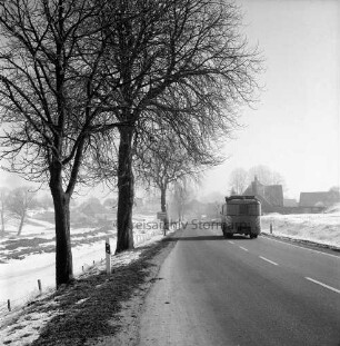 Stormarnstraße: Bundesstraße B 75 aus Richtung Hamberge: hinten rechts Lkw der Bundespost: links Ortseingangsschild zwischen Bäumen: im Hintergrund Wohn- und Bauernhäuser: Winter