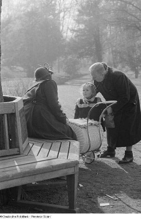 Zwei alte Frauen und ein Kleinkind sowie ein Kinderwagen im Park
